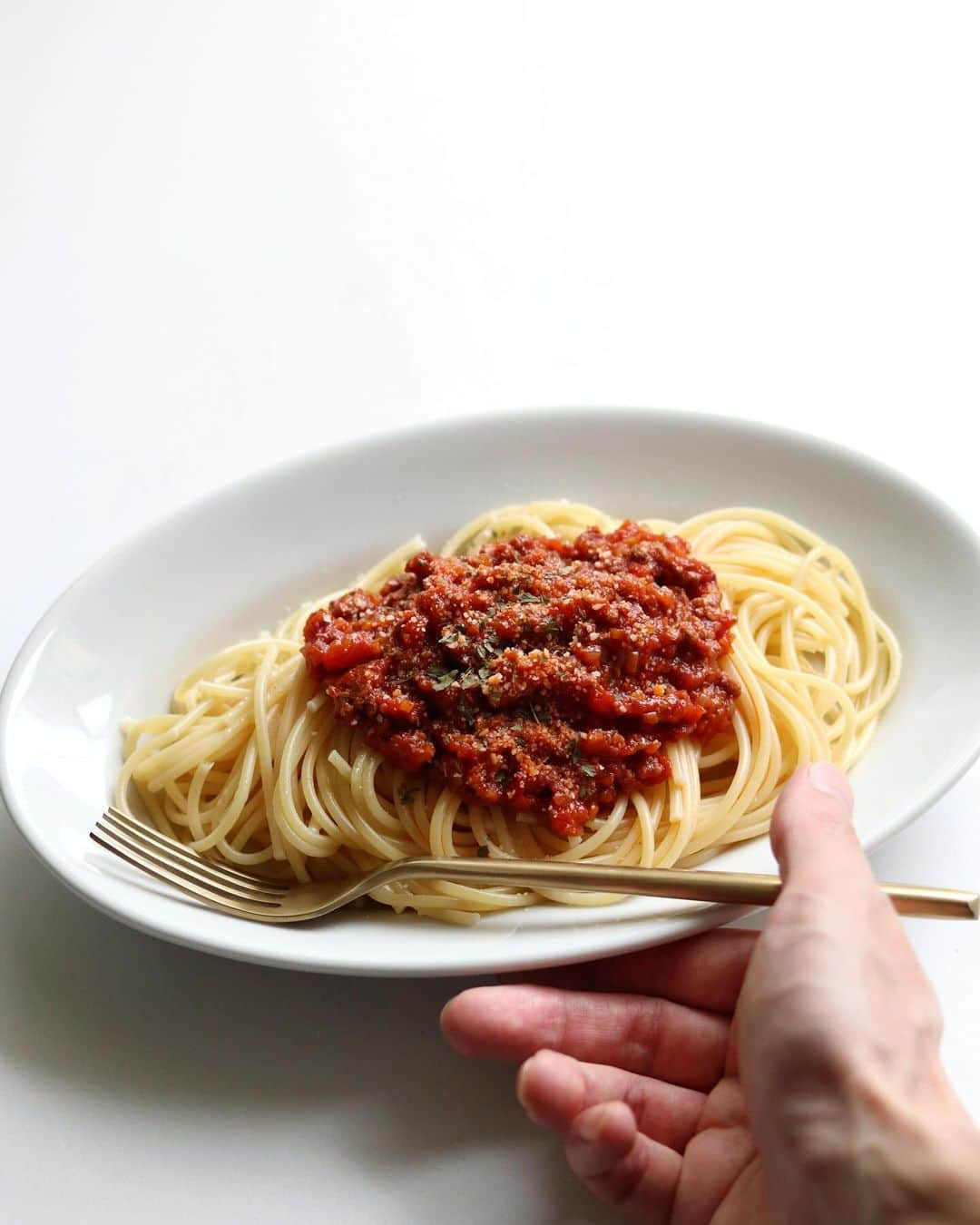 Ryogoのインスタグラム：「🍝 おうちで本格ミートソースパスタ。 ⁡ パスタ好きとか関係なくとりあえず覚えておくと役に立つ定番メニューのひとつ😊 作り置きやちょっとしたホームパーティーにもおすすめ！ ⁡ ——————————— ⁡ ▹レシピ本 初著書「おうちで本格！BINANPASTA流 映えうまパスタレシピ」(宝島社)が11/17に発売決定📙ハイライトの【🎁レシピ本】にリンクあります。 ⁡ ——————————— ⁡ ✱ 今日のパスタ 『本格ミートソースパスタ』 ⁡ ⋈ 材料(1人前)*ソースは3,4人前 パスタ　80g 合挽き肉　200g ☆にんじん（みじん切り）1/3本 ☆セロリ（みじん切り）1/2本 ☆玉ねぎ（みじん切り）1/2個 ☆ローリエ　1枚 トマト缶　1缶 トマトペースト　大さじ1 にんにく（みじん切り）1かけ オリーブオイル　大さじ2 赤ワイン　100ml ナツメグ　適量 粉チーズ　適量 乾燥パセリ　適量 塩　適量 ⁡ ⋈ 作り方 1. フライパンにオリーブオイルとにんにくを入れて弱火でじっくり香りを移します。 2. にんにくの香りがしてきたら、☆を加えて20分ほど炒めて一度別皿に取り出します。→★ 3. 空になったフライパンにひき肉と塩をひとつまみ入れて片面焼き色がつくまで中火で焼きます。 4. ひき肉の色が変わったらひっくり返し、軽くほぐして★を戻し混ぜ合わせたら、赤ワインを回し入れアルコールを飛ばします。 5. 次にトマト缶とトマトペーストを加えて水分が飛ぶまでじっくり弱火で煮詰めていきます。 6. 沸騰したお湯の中に塩を入れてパスタを茹で始めます。 7. ソースの水分が飛んだら、塩で味を整えナツメグ を加えて混ぜ合わせます。 8. 茹で上がったパスタをお皿に盛りミートソースを適量乗せたら、仕上げに粉チーズと乾燥パセリをトッピングして完成です。 ⁡ ⋈ 詳しくはHPでご紹介 https://binanpasta.com/meat-saucepasta/2/ *プロフィール(@binanpasta )からアクセスできます。←愛用アイテム一覧もあります。 ⁡ ✱「BINANPASTAのレシピを参考に作ったよ」という方は、ぜひ @binanpasta をタグ付けして写真を投稿してください。XやThreadsも大歓迎👏👏 ⁡ -——————————— ⁡ ▹YouTube 2チャンネルあります。チャンネル登録してね🍳 ・まかない食堂 ・BINANPASTA ⁡ ▹レシピサイト(BINANPASTA) 約700種類のパスタレシピを無料で公開しています🍝 *プロフィール(@binanpasta )からも飛べます。 ⁡ #BINANPASTA #パスタレシピ #私のおうちパスタ  ⁡ -——————————— ⁡ #パスタ #レシピ #フーディーテーブル #おうちごはん #ミートソース」