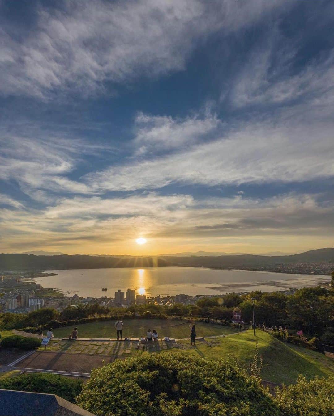 ?長野県 観光 公式インスタグラム のインスタグラム：「// Photo by @tom_mx_5  絶景の公園 「立石公園」 ＠諏訪市  標高934mの高台にある「立石公園」  眼下には諏訪湖、岡谷市や下諏訪町の町並み、  天気が良ければ北アルプスの山々も 望むことができます 🏔✨  諏訪湖に沈む夕陽や美しい夜景もロマンチック 💕✨️  あの大ヒットアニメ映画の劇中に登場する 景色に似ていると人気のスポットです😀✨️  ＝＝＝＝＝＝＝＝＝  Tateishi Park (Suwa City)  Tateishi Park sits on a hillside at an altitude of 934 meters.   From the park, you can see Lake Suwa and the townscapes of Okaya and Shimosuwa below, and if the weather is good, even the Northern Japanese Alps in the distance.  The sunset over Lake Suwa and the surrounding nightscapes are romantic.  It is also popular for its scenery’s resemblance to the backdrop of that hit anime film—you’ll know it if you’ve seen it!  ＿＿＿＿＿＿＿＿＿　  Location / Suwa City , Nagano , Japan   #おうちでながの #長野のいいところ #立石公園 #諏訪市  ＿＿＿＿＿＿＿＿＿  🍁インスタアワード秋冬⛄作品募集中📷  #長野の列車旅秋冬 撮影場所(長野県内に限ります) をキャプションに入れて 応募期間（10/16～1/31）に投稿してください。 優秀作品に選ばれると 長野県特産品セットをプレゼント🎁」