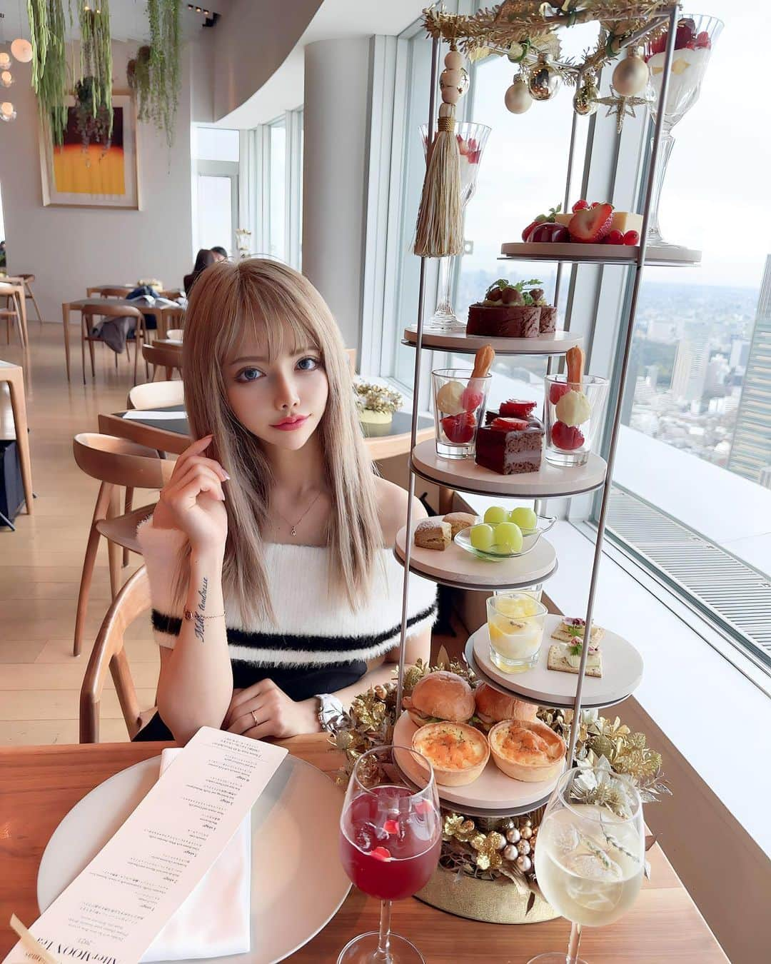 さとのんのインスタグラム：「. クリスマスアフタヌーンティー🎄 Gorgeous！Christmas AfterMOON Tea-2023- @themoon_roppongi   ゴールドの装飾がキラキラしててかわいい💓‪  トリュフや栗、シャインマスカット すきなものばかりだった🥹  12/22〜12/25の間はセイボリーの一部が 変わるみたいだよ💓‪  【メニュー】 ♥️1stage ガトーフロマージュ チョコレートトリュフ(練乳orカシス)季節のベリー 💚2stage マロンとチョコレートのブッシュドノエル 苺のクリスマスパフェ ♥️3stage ホワイトチョコレートトリュフのグラスデザート ガナッシュケーキ 💚4stage 抹茶のスコーン シャインマスカットとクリスタルゼリー ♥️5stage 自然卵の温泉玉子とトリュフ 生ハムとチーズのクラッカー 💚6stage ポークパストラミのブリオッシュサンド カニとカリフラワーのキッシュ ━━━━━━━━━━━━━━━ 11/7(火)〜12/25(月) ￥7,000(税込)＋サービス料10% ※窓際の席はチャージ￥2,000(1テーブル)  #六本木ヒルズ  #六本木展望台  #themoon  #六本木アフタヌーンティー  #東京アフタヌーンティー」