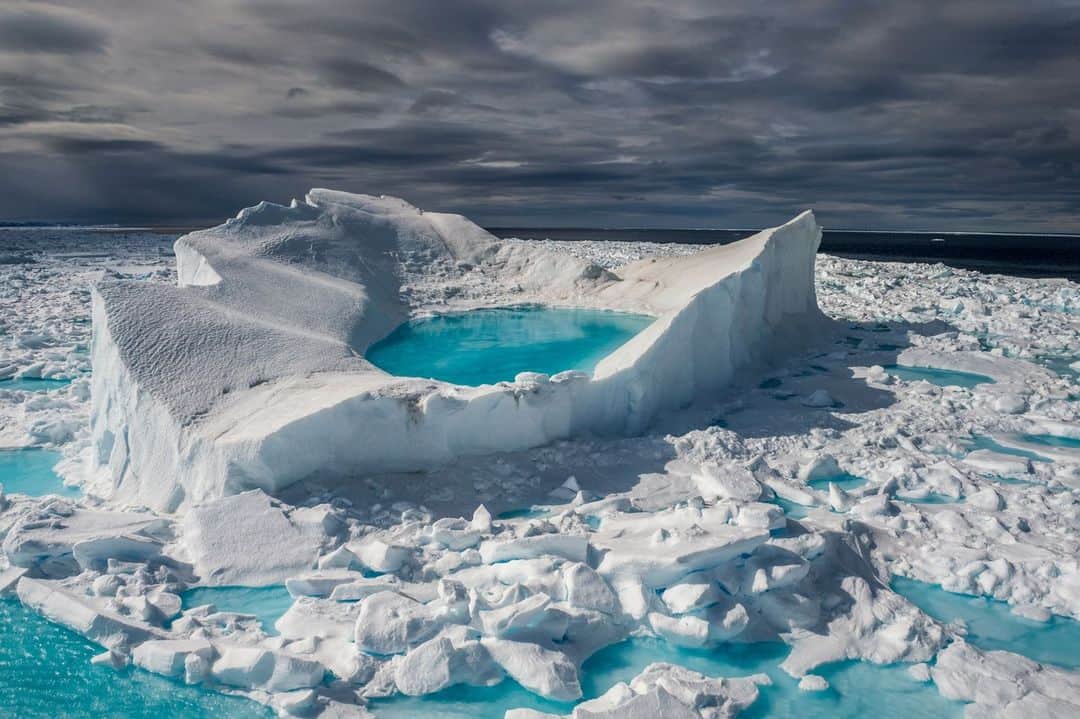 ナショナルジオグラフィックのインスタグラム：「Beautiful and rugged, the Arctic and Antarctic regions have an alien charm. But as the climate warms, these polar ecosystems have become some of the most vulnerable on Earth. Explore their beauty and fragility through these images and read more at the link in bio.  📸 @brianskerry | In Nunavut, Canada, sea ice melts into turquoise pools of water beneath the June summer sun. These melt pools accelerate the rate of warming in a region already warming faster than anywhere else on Earth.  📸 @thomaspeschak | About eight million chinstrap penguins live on the Antarctic Peninsula. There are no land-based predators on the continent of Antarctica, which has allowed penguin populations to flourish, but warming temperatures are making it harder for them to survive.  📸 @katieorlinsky | The Batagaika crater in eastern Siberia is the world's biggest permafrost crater. Permafrost is permanently frozen ground that contains thousands of years' worth of dead plants and animals, but as the Arctic rapidly warms, this ground is thawing. In addition to destabilizing the ground, melting permafrost releases large quantities of greenhouse gases.   📸 @renan_ozturk | A team of explorers aboard the ship Polar Sun travels through Arctic waters to trace the route of Sir John Franklin, a British naval officer who led a doomed 19th-century expedition through the Canadian Arctic.  📸 @ronan_donovan | On Ellesmere Island in Nunavut, arctic wolves feast on the carcass of a musk ox, a type of long-haired, horned ox that roams the Arctic tundra.」