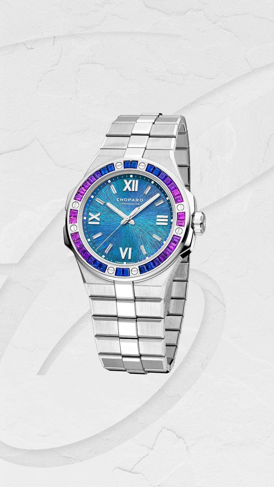 ショパールのインスタグラム：「Featuring the collection’s emblematic eagle-eye sunburst-patterned dial in a hue inspired by the eponymous Zinal glacier, the new #AlpineEagle Blue Zinal whisks you into a world of natural beauty that the Maison is determined to protect.​ With its bezel set in trapeze-cut​ blue and purple sapphires, the 41 millimetre-diameter case and bracelet are crafted in 18-carat Ethical Gold, while at its heart beats the COSC-certified #Chopard 01.15-C self-winding movement.​ #FreshFromOurAteliers #ManWithAVision #ChopardWatch #SwissMade #LuxuryWatch​」