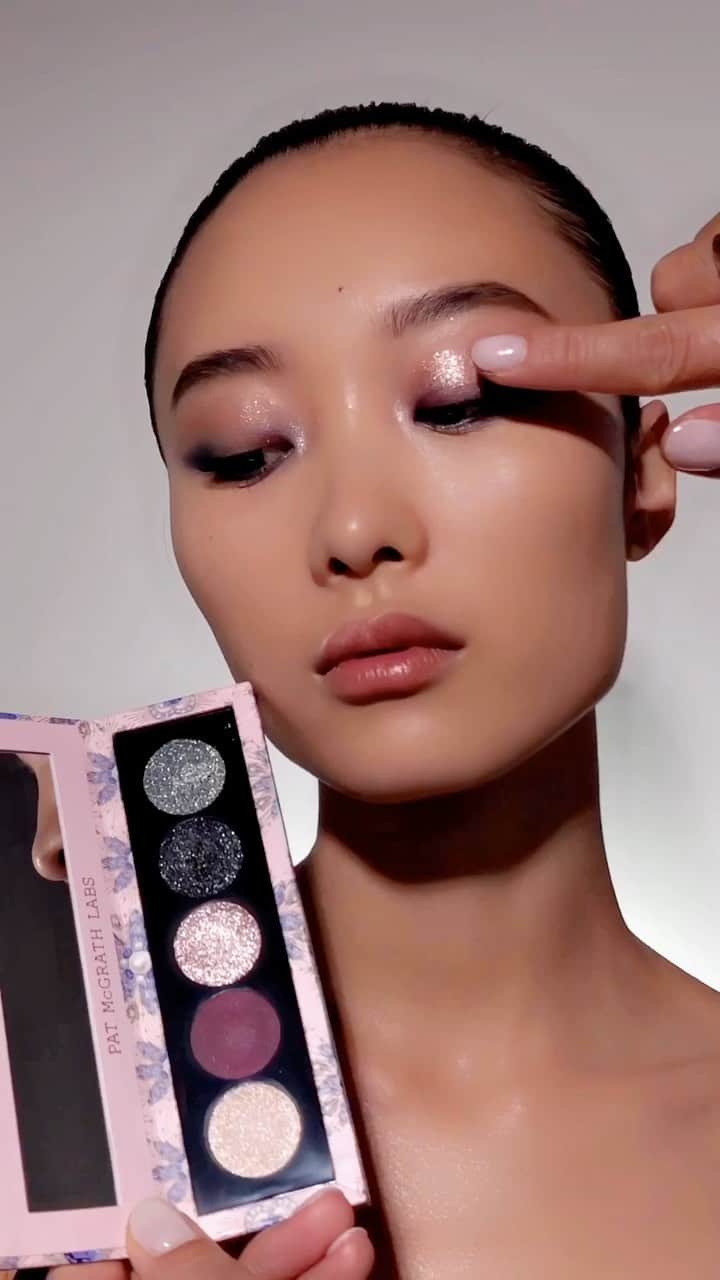 パット・マグラスのインスタグラム：「DIVINE DECADENCE ✨💎✨Turn heads this #Holiday2023 with #McGrathMuse @hey0arah, slaying in the Divine Blush + Bronze + Glow Trio: Fleurever Nude &  Bijoux Brilliance Eye Shadow Palette: Lunar Nightshade.✨💎✨ Shop NOW at PATMcGRATH.COM  ✨STARRING✨ FACE Divine Blush + Bronze + Glow Trio: Fleurever Nude ‘NUDE HONEY’ - Neutral Bronze ‘NAKED PEONY’ - Bright Warm Pink EYES Bijoux Brilliance Eye Shadow Palette: Lunar Nightshade ‘PLATINUM MOONLIGHT’ - Platinum Champagne Shimmer ‘PALE AMETHYST’ - Platinum Taupe Metallic  ‘NOIR NEBULA’ - Deep Indigo Metallic with Teal Sparkle  FetishEYES™ Mascara」