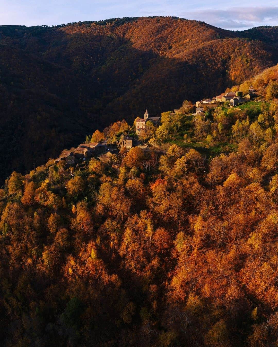 Alex Strohlのインスタグラム：「This morning in a deep Ardeche valley. I’ve been photographing this tiny village for a lot of years but this is the first time I try this wider perspective — usually I bring out the telephoto and fire away. Crazy that the chestnuts are at their peak colors mid November.. Usually this happens in late October. A very peaceful morning nonetheless.」