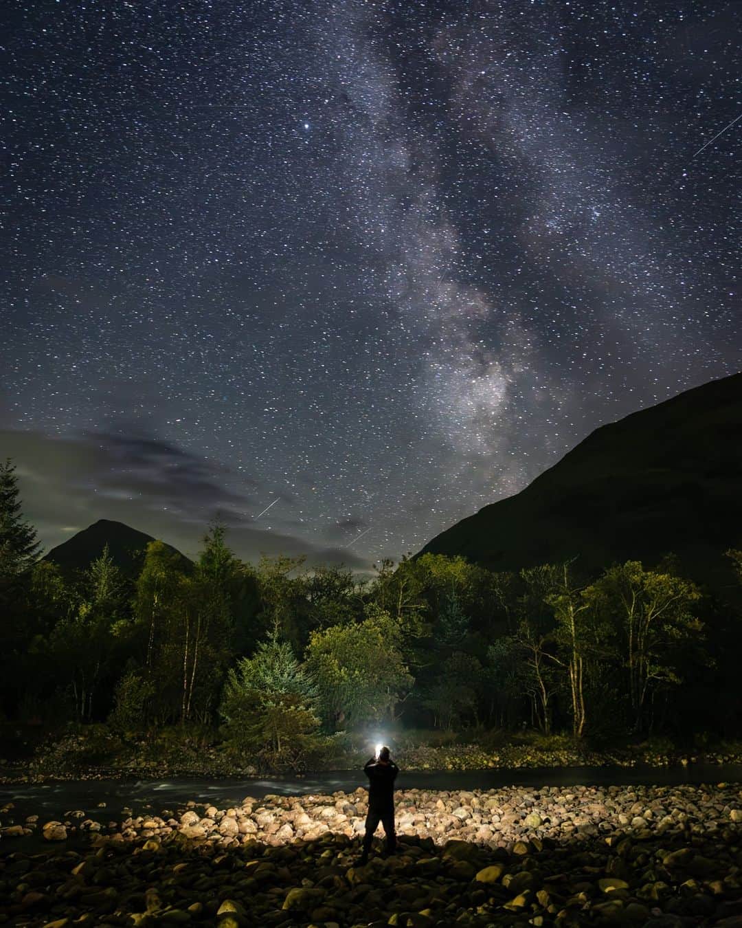 Canon UKのインスタグラム：「Have you ever wondered what goes on behind the lens? 📸🌠  If so, here’s the story of how @fabsinthe captured this stunning shot:  “Whilst on a trail mountain race weekend in Scotland with some friends, we stayed at the red squirrel campsite in Glencoe. Alas there were no red squirrels but we were treated to a completely clear, still and moonless night with the perfect view of the Milky Way over the distant Munros. I set up a tripod, dialled in the settings and then ran into the shot and shone my phone torch upward to try and highlight how small I felt compared to the vastness of what was in my line of sight.”  #canonuk #mycanon #canon_photography」