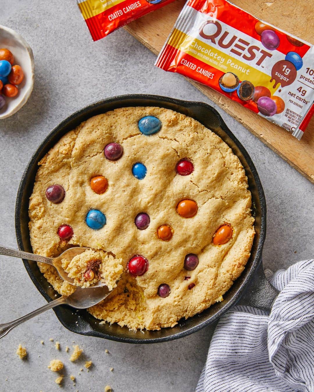 questnutritionのインスタグラム：「Questified Peanut Butter Skillet Cookie with Coated Candies 💪🍪🍬😍🔥 • 👉 FULL RECIPE LINK IN BIO (swipe left to 2nd card)👈 • Per serving: 9g protein, 7g carb, 12g fat. (4g net carbs) #OnaQuest #QuestNutrition #QuestCandy」