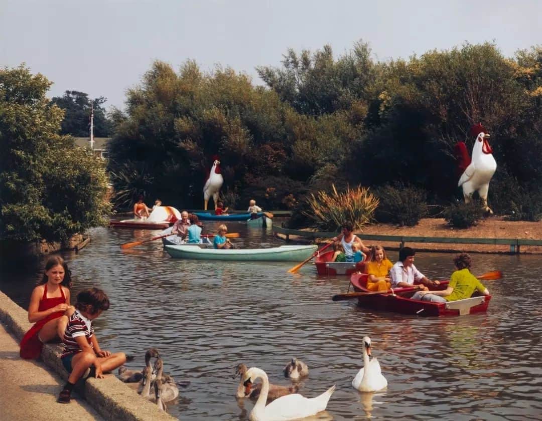 テート・ギャラリーのインスタグラム：「Wish you were here. 🏖️ 🍹  These are just a few of the nineteen colour photographs in Tate’s collection from a larger series of images which were produced by the postcard company John Hinde Ltd documenting the British holiday camps run by the Butlin’s company.  The Hinde company’s postcards were the product of meticulous planned photoshoots, with careful staging and alteration both at the point of shooting and in post-production. Hinde company photographer Elmar Ludwig described how, ‘we always tried to make more out of a scene. There was never an easy picture.’  The Butlin’s project was among the most challenging commissions undertaken by John Hinde Ltd. Shot with large format cameras, and lit like a film set, the production of these photographs was a significant undertaking, with photographers working on one particular image for the entire day.  Hinde had his images printed in Italy, where colour printing was more advanced and could satisfy the colour saturation he desired. He would personally review and make amendments to the work carried out by the photographers he employed. Photographer Edmund Nagele recalled, ‘telephone poles cars and tv aerials were marked down for magic removal. Bland skies were simply replaced by a short scribble “new sky”.’ This attention to detail and level of alteration set Hinde’s work apart from other postcard photographers of the time. Hinde wished his postcards to correspond more closely to the image of a place that tourists might carry away in their memory.  🏖️ Butlin’s Bognor Regis, The Boating Lake, c.1970, printed 2002 💃 Butlin’s Bognor Regis, The Regency Ballroom, c.1970, printed 2002 🛝 Butlin’s Ayr, A Corner of the Children’s Playroom, c.1970, printed 2002 🛋️ Butlin’s Ayr, A Quiet Lounge, c.1970, printed 2002 🍹 Butlin’s Skegness, The Beachcomber Bar, c.1970, printed 2002 📸 Butlin’s Pwllheli, Old Tyme Ballroom, c.1970, printed 2002 🏊 Butlin’s Mosney, Coffee Lounge Adjoining Indoor Heated Pool, c.1970, printed 2002 🕹️ Butlin’s Barry Island, The Main Arcade, c.1970, printed 2002」