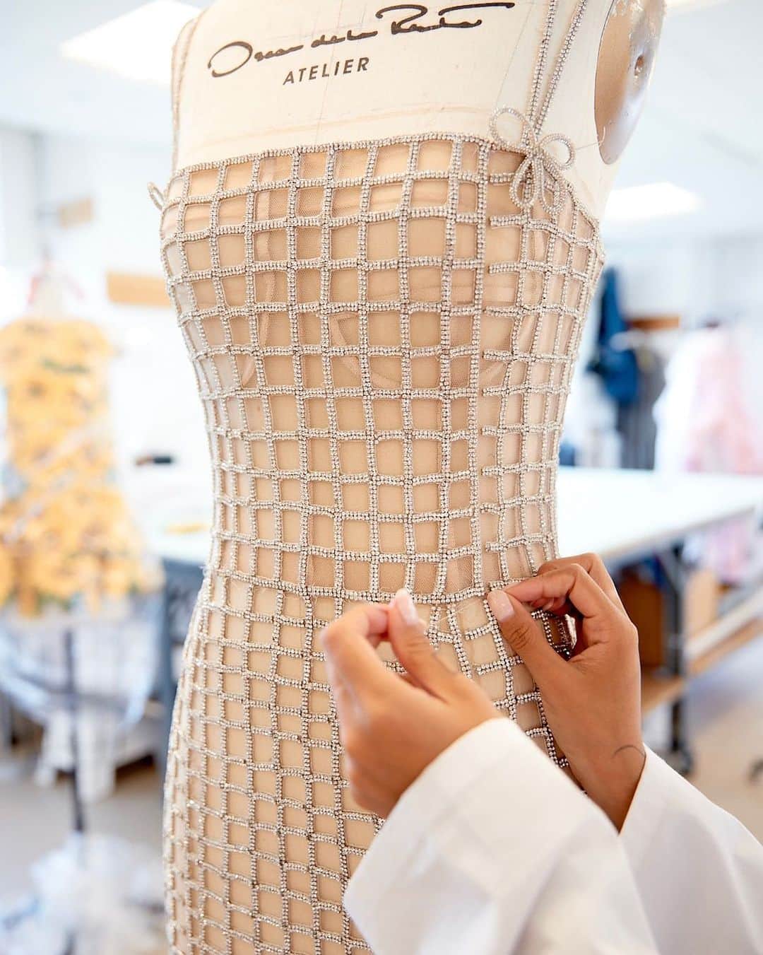 オスカーデラレンタのインスタグラム：「Crafted of crystals, the #odlrprespring2024 embroidered grid dress receives finishing touches by modistes in our New York City atelier.  Discover the collection at the link in bio.」