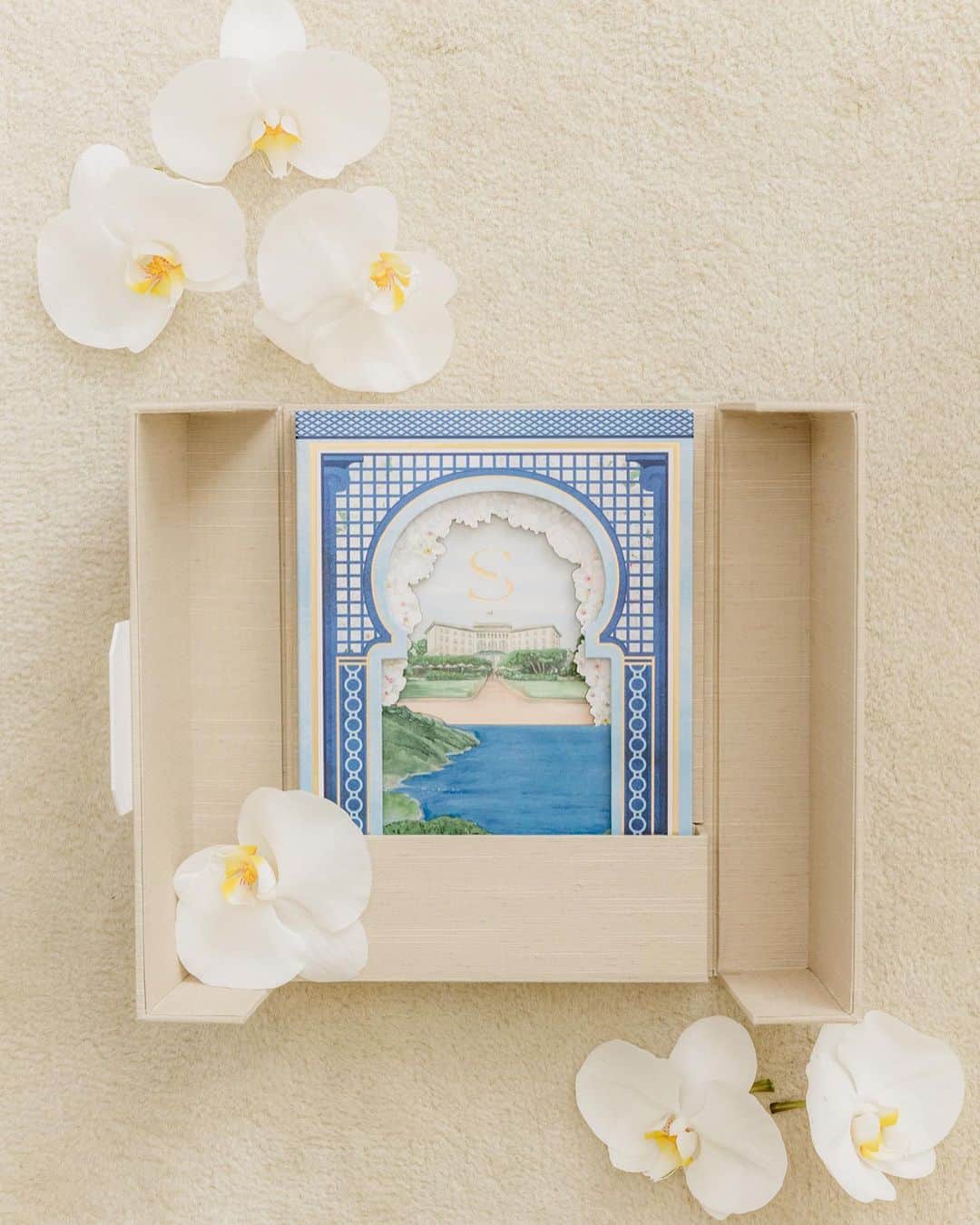 Ceci Johnsonのインスタグラム：「WEDDING | Presenting a closer look at this couture invitation inspired by the Four Seasons Cap-Ferrat, France –S&A’s wedding venue. Outside, the box is hand wrapped in neutral linen, opening to reveal a book invitation that invites guests on a journey to celebrate their love. The book’s cover features a hand painted 3D watercolor art depiction of their wedding venue. Each page inside is a canvas inspired by the locations of their welcome party at @yachtclubmonaco, white-orchid wedding, and poolside brunch at @fscapferrat. To complement this couture experience, a matching welcome booklet has been crafted, incorporating a tassel for an added touch of refinement.  #CeciCouture ⠀⠀⠀⠀⠀⠀⠀⠀⠀ CREATIVE PARTNERS: Luxury Invitation & Event Branding: @cecinewyork Planning & Design: @lavenderandroseweddings Welcome Party Venue & Catering: @yachtclubmonaco Wedding Venue & Catering:  @fscapferrat Photography: @daniloandsharon ⠀⠀⠀⠀⠀⠀⠀⠀⠀ #cecinewyork #ceciwedding #lavenderandroseweddings #luxuryinvitations #elegantdesigns #coutureinvites #opulentdetails #bespokeinvitations #chiccelebrations #artistryininvitations #highenddesigns #luxurystationery #premiuminvitations #exquisitedetails #invitationelegance #celebrateinstyle #glamorousinvites #luxurycelebrations #finestationery #customizedelegance #celebrationperfection #invitationcouture #elevateyourevent #luxuryeventplanning」