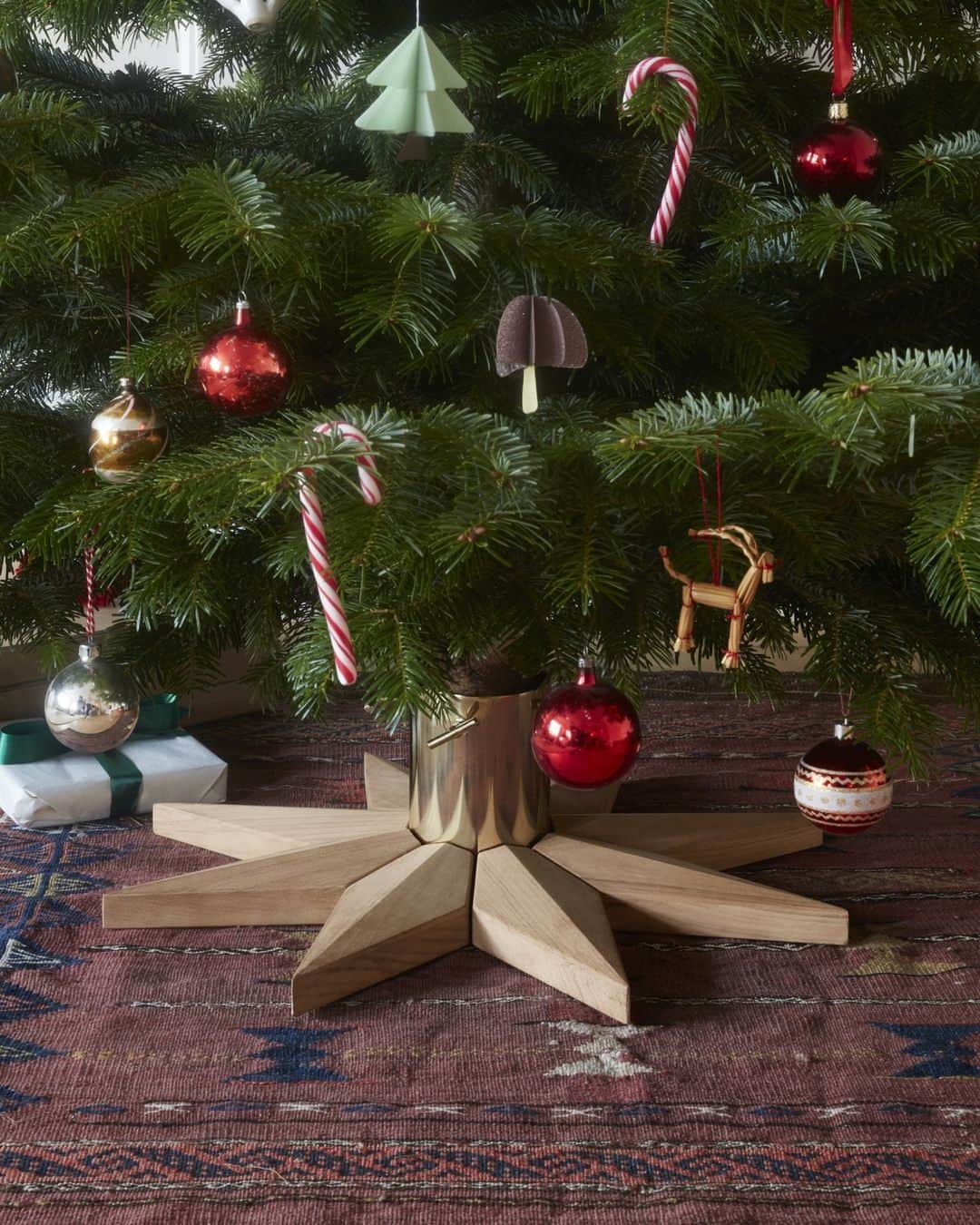 フリッツハンセンのインスタグラム：「Decorate every part of your tree with the Stella Christmas Tree Base. ⁠ ⁠  An eight-point star made from FSC™-certified oak and warm brass holds the tree securely in place. A gilt cup holds water to keep the tree from drying out all season long. ⁠ ⁠ Crafted to last so you can make it a tradition year after year after year… ⁠ ⁠ Shop the Stella Christmas Tree Base via the link in bio. ⁠」
