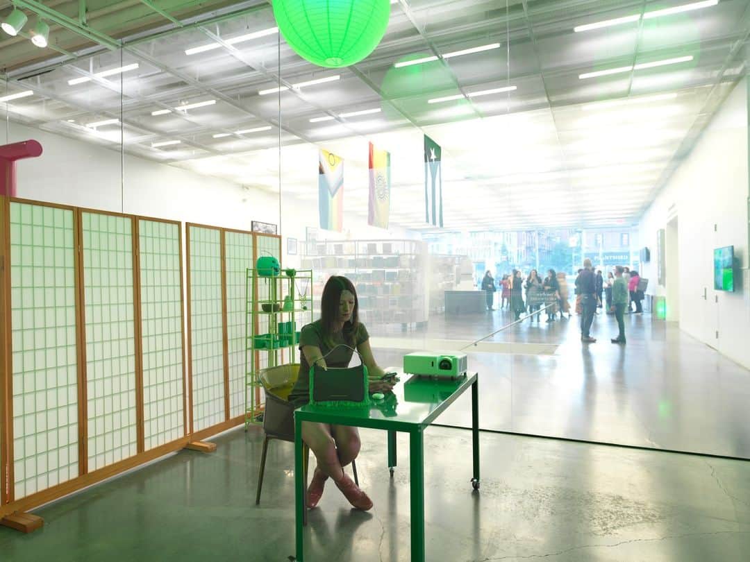 ニュー・ミュージアム・オブ・コンテンポラリー・アートのインスタグラム：「Visitors to the exhibition, "Puppies Puppies (Jade Guanaro Kuriki-Olivo): Nothing New," may encounter the artist lounging on a bed, sitting at her desk, or hosting guests in a restaging of her bedroom. Playing with visibility and performativity, Kuriki-Olivo has installed “smart glass” that she can turn on or off to obscure or reveal her activities within this central section of the gallery. When the artist is present, visitors can observe her through the glass (if Kuriki-Olivo allows), or through two CCTV-style cameras that are also constantly filming her. When she is offsite, viewers can still follow her actions via a live video feed that is periodically streamed into the Museum’s Lobby.   This installation marks a sharp pivot in Kuriki-Olivo's practice away from anonymity and towards radical visibility and (literal) transparency. As a whole, "Nothing New" evokes complex layers of intimacy, pointing to both Kuriki-Olivo’s lived experiences and the societal and technological apparatuses by which we relate to ourselves and each other.  📷 “Puppies Puppies (Jade Guanaro Kuriki-Olivo): Nothing New,” 2023. Exhibition view: New Museum, New York. Courtesy New Museum. Photo: Dario Lasagni; @lizligon」