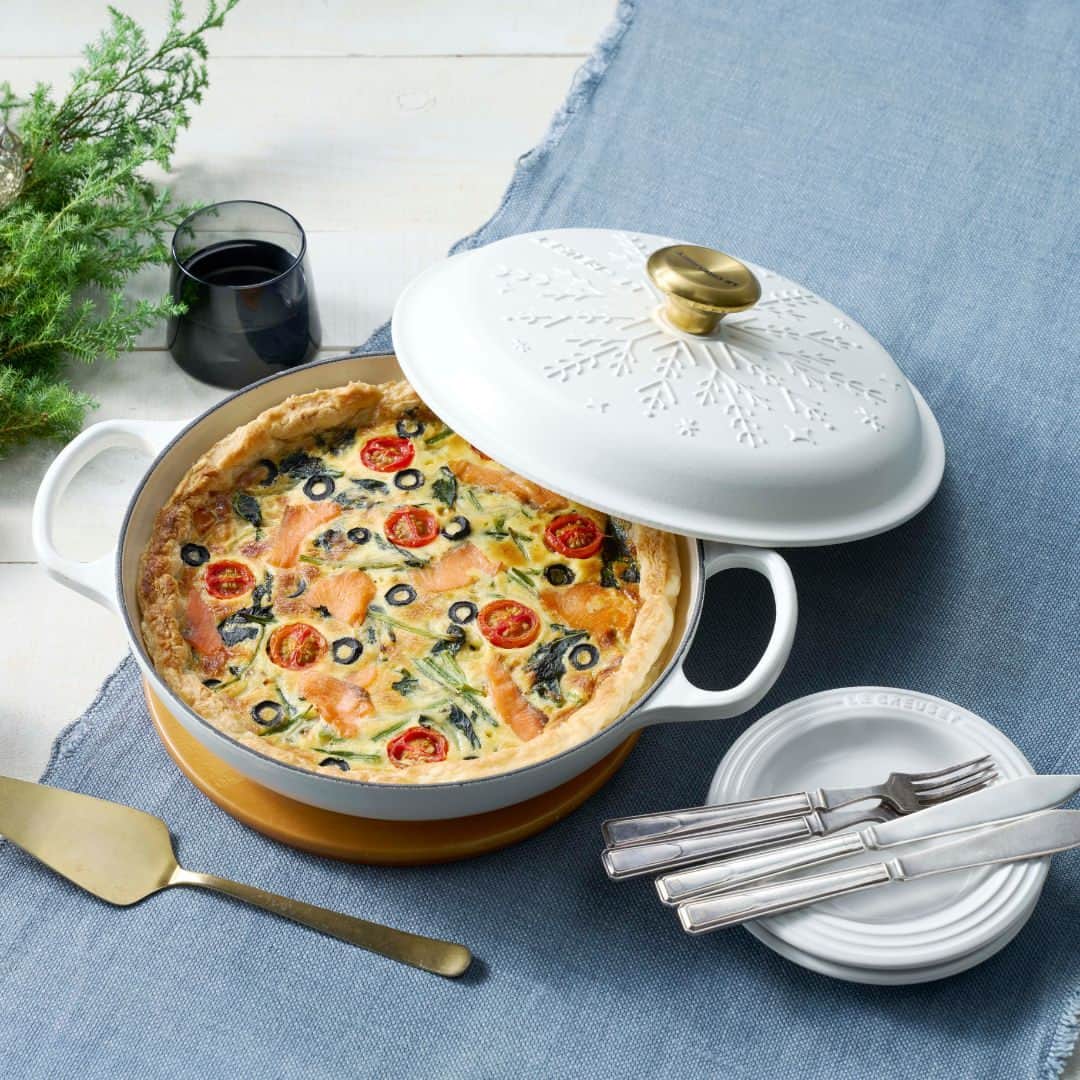 Le Creuset Japon　ル・クルーゼ ジャポンさんのインスタグラム写真 - (Le Creuset Japon　ル・クルーゼ ジャポンInstagram)「【ル・クルーゼ 公式レシピ】冷めてもおいしい！スモークサーモンとほうれん草のキッシュ  彩り鮮やかでパーティーなどのおもてなし料理としてもぴったりな一品。冷凍パイシートで簡単に作れる具だくさんのキッシュは冷めてもおいしくいただけます。旬の食材やお好みの具材でのアレンジも楽しめますよ。  ======材料====== (6〜8人分/シグニチャー ビュッフェ・キャセロール 26cm使用)  冷凍パイシート・・・3枚 スモークサーモン・・・100ℊ ほうれん草・・・1袋(200g) 玉ねぎ・・・1/2個(100g) ミニトマト・・・4個 黒オリーブ（種抜き）・・・4個 オリーブオイル(炒め用)・・・大さじ1/2 オリーブオイル(塗る用)・・・適量  (A) 溶き卵・・・3個分 ピザ用チーズ・・・100ℊ 生クリーム・・・150ml 塩・・・小さじ1/2  ======下準備====== ・ほうれん草はざく切り、玉ねぎは薄切りにする。 ・ミニトマトは半分に切り、オリーブは輪切りにする。 ・冷凍パイシートは冷蔵庫で戻す。 ・オープンは200℃に予熱する。  ======作り方======  1.鍋にオリーブオイルを入れ中火で熱し、ほうれん草、玉ねぎを炒める。火が通ったら粗熱を取る。  2.(A)をボールに入れて混ぜ合わせ、スモークサーモンと1.を加えて混ぜる。  3.同じ鍋を洗って拭き、オリーブオイルを塗っておく。パイシート3枚のうち1枚を半分に切る。残り2枚を横に並べて、半分に切ったパイシートを上下に並べる。麺棒でのばして鍋に合うように形を調整し、敷き詰める。パイシートは鍋の8割程度の高さまで。底にフォークで数か所穴をあける。  4.2.を3.に流し入れて、ミニトマト、オリーブを散らす。200°Cに予熱したオープンで30～40分ほど焼く。相熱が取れてから鍋から取り出してください。  #ルクルーゼ #lecreuset #ルクルーゼのある暮らし  #ルクルーゼごはん #テーブルウェア #テーブルコーディネート #キッチンウェア #キッチングラム #ルクルーゼのある生活 #ルクルーゼのある食卓 #食卓 #食卓グラム #キッチンツール    #シグニチャービュッフェキャセロール #鍋 #鍋レシピ #キッシュ #冬野菜 #夕飯 #夕飯レシピ」11月19日 13時00分 - lecreusetjapon