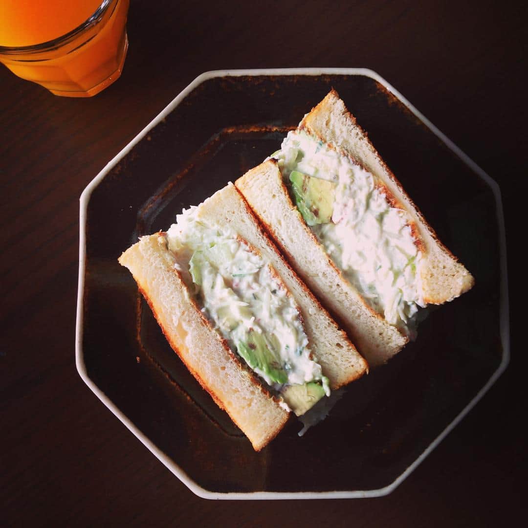 志摩有子さんのインスタグラム写真 - (志摩有子Instagram)「クリスマス用の蟹が残っていたので、セロリ、アボカド、玉ねぎとサワークリームとマヨで和えてサンドイッチに。沼サン風に具たっぷりに。当たり前だけど、沼さん皿にはがっつりサンドイッチがよく似合う。風邪気味の体にみかんジュースでビタミン補給🍊🍊🍊 #sunday #sandwich #蟹 #アボカド #balmuda #バルミューダ #トーストモード #サンドイッチ #沼サン風 #沼サン皿 #大沼道行」12月27日 13時30分 - ariko418
